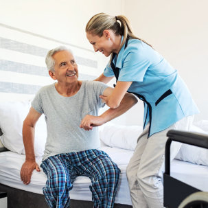 caregiver helping senior man get up