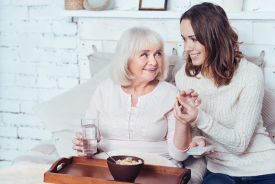 caregiver together with elderly woman sitting on chair